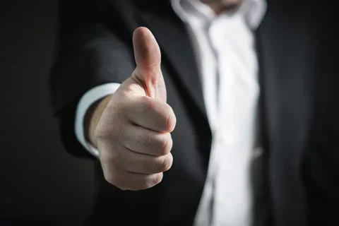 Man in a suit giving thumbs up