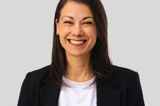 Headshot of Dr. Luisa Blanco with smile wearing a black jacket and white shirt.