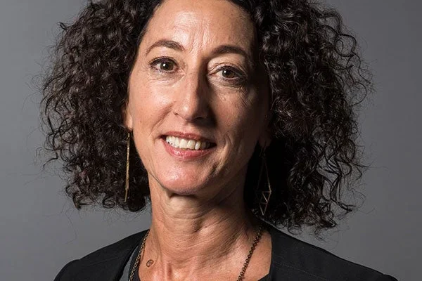 Woman with curly brown hair smiling