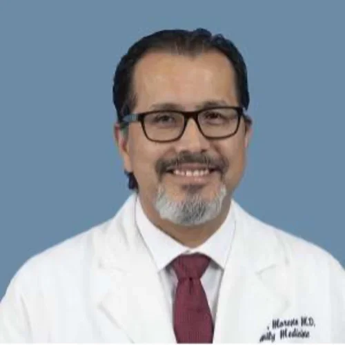 Dr. Gerardo Moreno pictured with glasses, white medical coat and red tie