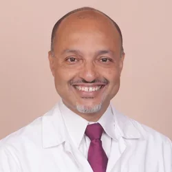 Headshot of Dr. Kenrik Duru in medical coat and red tie