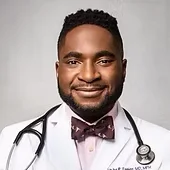 Photo is face of Dr. Utibe Essien, who is a black man with a beard in his medical white coat with a stethescope around his neck.