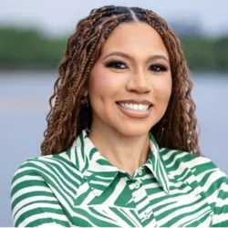 Women with brown curls smiling with green and white shirt