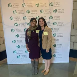 Drs. Cecilia Canales and Alejandra Casillas standing in front of a conference backdrop. 