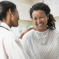 A surgeon talks with a female patient during a health visit. 