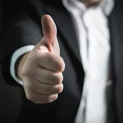 Man in a suit giving thumbs up 