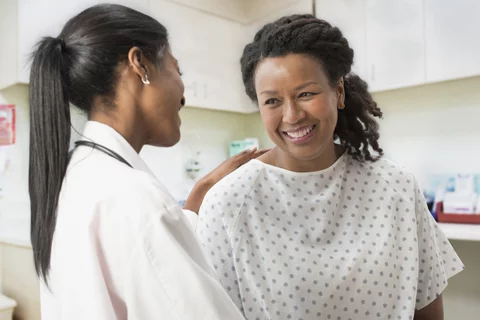 A surgeon talks with a female patient during a health visit.