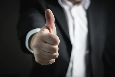 Man in a suit giving thumbs up
