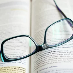 Reading glasses on top of an open book.